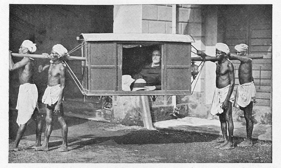Colonial India, British man being carried in a wooden box type contraption. 