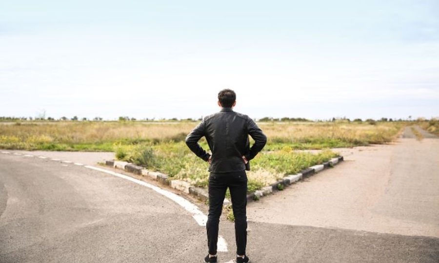 man standing infront of a split in the road